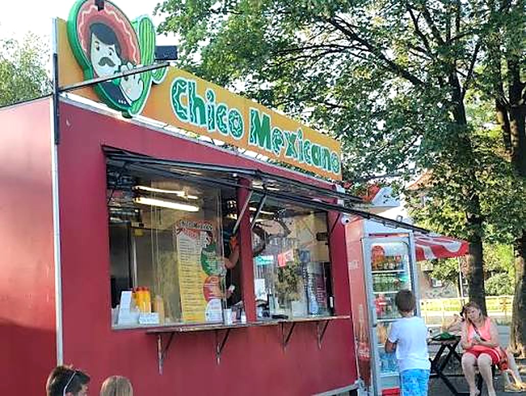 Czerwona budka Chico Mexicano w ciągu dnia — klienci zamawiają przez okienko